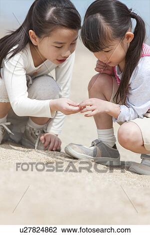 Stock Image - Two Girls Playing on Beach. Fotosearch