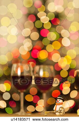 Stock Image - Two Glasses of Red Wine and Christmas Decorations. Fotosearch