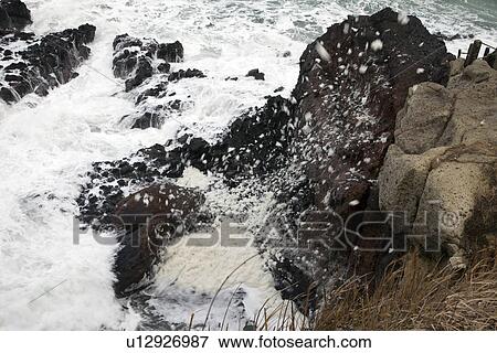 Stock Photo - Waves splashing against rocks. Fotosearch