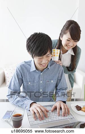 Stock Photography - Young Couple Typing. Fotosearch