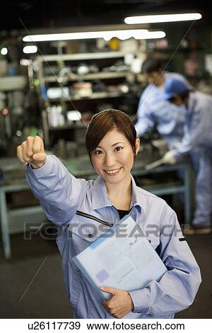 Stock Photo - Young Female Factory Worker With Fist Raised. Fotosearch