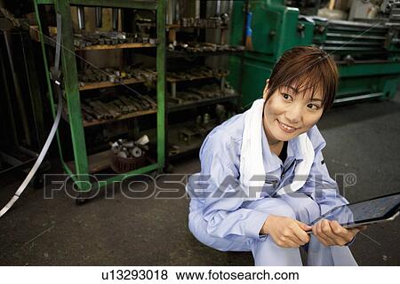 Stock Photo - Young Female Worker Using Digital Tablet. Fotosearch