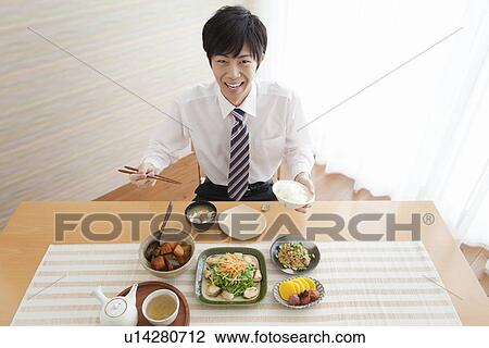 Stock Image - Young Man Having Breakfast. Fotosearch