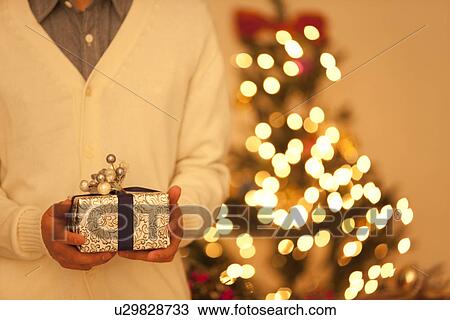 Young Man Holding Christmas Present View Large Photo Image Stock Image - Young Man Holding Christmas Present. Fotosearch