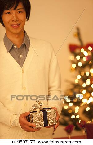Stock Photo - Young Man Holding Christmas Present. Fotosearch