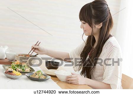 Stock Image - Young Woman Eating Breakfast. Fotosearch