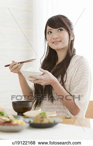 Stock Photo - Young Woman Eating Breakfast. Fotosearch