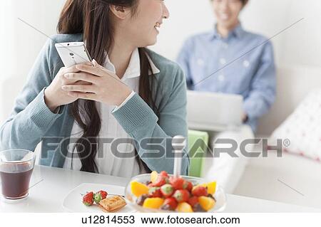 Stock Image - Young Woman Giggling at Text Message. Fotosearch