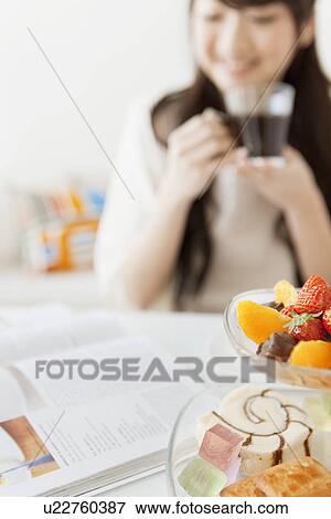 Stock Photo - Young Woman Having Tea and Reading Magazines. Fotosearch