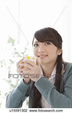 Stock Image - Young Woman Having Tea. Fotosearch