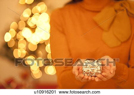 Stock Image - Young Woman Holding Christmas Present. Fotosearch