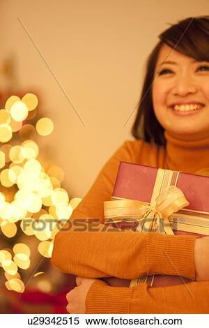 Young Woman Holding Christmas Present View Large Photo Image Stock Photography - Young Woman Holding Christmas Present. Fotosearch