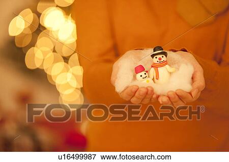 Stock Photo - Young Woman Holding Snowmen. Fotosearch
