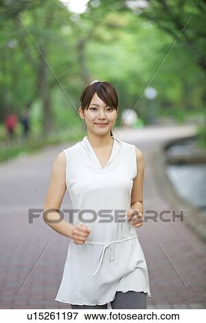 Young Woman Jogging Along Riverside in Spring View Large Photo Image Stock Photo - Young Woman Jogging Along Riverside in Spring. Fotosearch