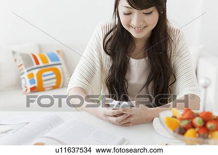 Young Woman Texting at Table View Large Photo Image Picture - Young Woman Texting at Table. Fotosearch