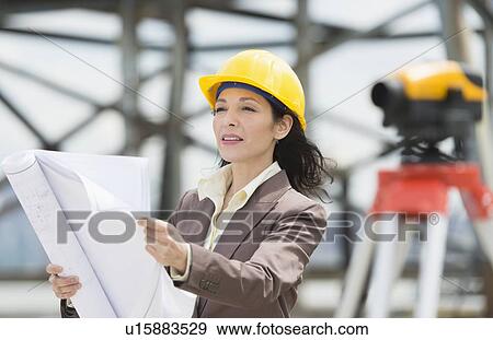Architect reading blueprint in construction site View Large Photo Image Stock Photo - Architect reading blueprint in construction site. Fotosearch