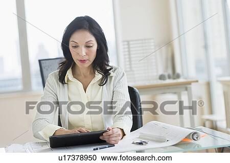 Architect working on digital tablet in office View Large Photo Image Stock Image - Architect working on digital tablet in office. Fotosearch
