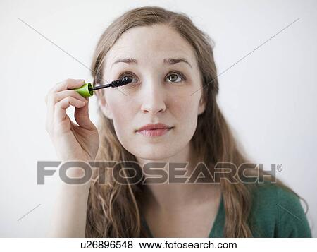 Attractive young woman applying mascara View Large Photo Image Stock Photo - Attractive young woman applying mascara. Fotosearch