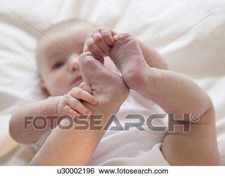 Baby boy (2-5) touching foot View Large Photo Image Stock Photograph - Baby boy (2-5) touching foot. Fotosearch