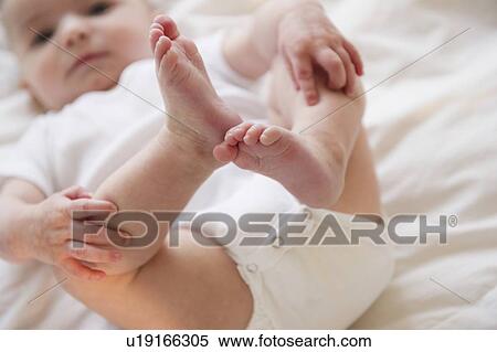 Stock Photography - Baby boy (2-5) touching legs. Fotosearch