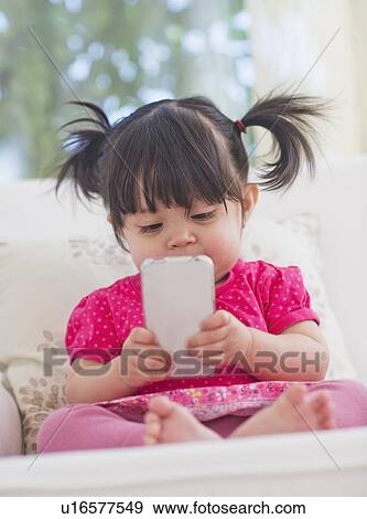 Baby girl (12-17 months) playing with mobile phone View Large Photo Image Stock Photo - Baby girl (12-17 months) playing with mobile phone. Fotosearch