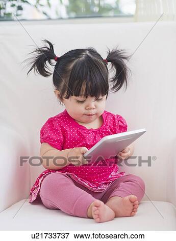 Baby girl (12-17 months) playing with digital tablet View Large Photo Image Stock Photo - Baby girl (12-17 months) playing with digital tablet. Fotosearch