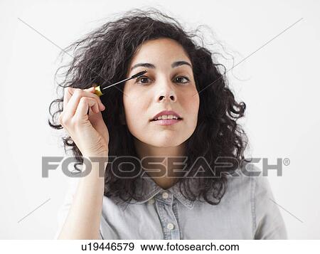 Beautiful young woman applying mascara View Large Photo Image Stock Photo - Beautiful young woman applying mascara. Fotosearch