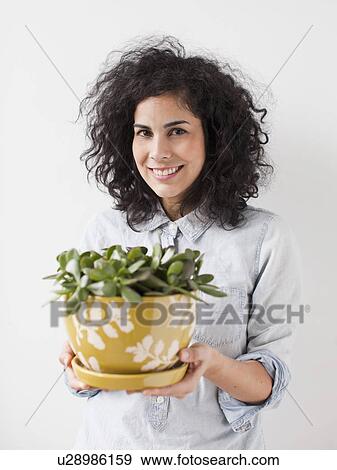 Beautiful young woman holding pot plant View Large Photo Image Stock Photo - Beautiful young woman holding pot plant. Fotosearch