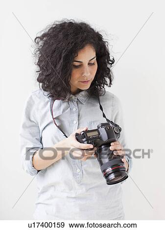 Stock Photo - Beautiful young woman holding professional camera. Fotosearch