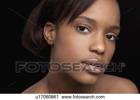 Stock Image - Beautiful young woman looking at camera. Fotosearch