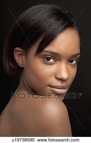 Stock Image - Beautiful young woman looking at camera. Fotosearch