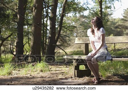 Belgium, Kalmthoutse Heide, Young woman sitting on bench View Large Photo Image Stock Image - Belgium, Kalmthoutse Heide, Young woman sitting on bench. Fotosearch