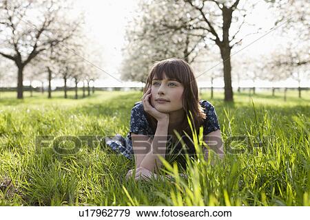 Belgium, Sint-Truiden, Portrait of young woman in spring orchard View Large Photo Image Stock Photo - Belgium, Sint-Truiden, Portrait of young woman in spring orchard. Fotosearch