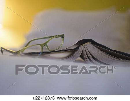 Book and eyeglasses on bed View Large Photo Image Stock Image - Book and eyeglasses on bed. Fotosearch