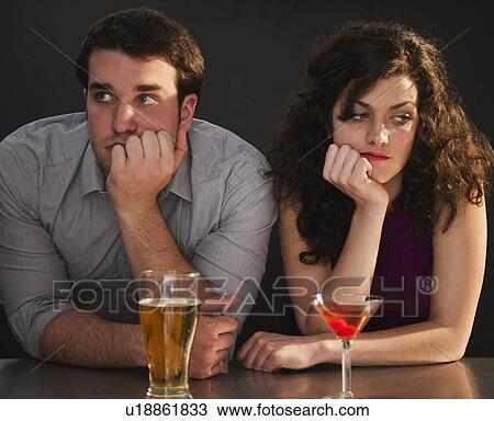 Bored couple sitting at bar counter View Large Photo Image Stock Image - Bored couple sitting at bar counter. Fotosearch