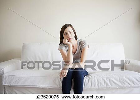 Bored young woman sitting on bed View Large Photo Image Stock Photography - Bored young woman sitting on bed. Fotosearch