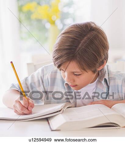 Boy (10-11 years) doing homework at table View Large Photo Image Stock Photo - Boy (10-11 years) doing homework at table . Fotosearch