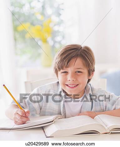 Boy (10-11 years) doing homework at table View Large Photo Image Stock Photo - Boy (10-11 years) doing homework at table . Fotosearch