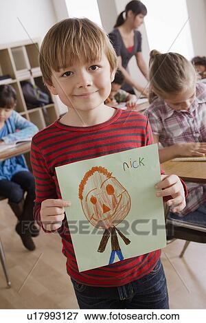 Boy (6-7) showing his drawing View Large Photo Image Stock Photo - Boy (6-7) showing his drawing. Fotosearch