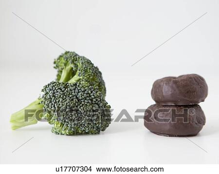 Picture - Broccoli and chocolate cookies on white background, studio shot. Fotosearch