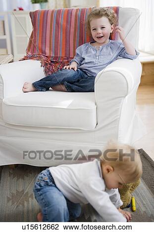 Stock Image - Brother and sister (2-3, 6-11 months) at home. Fotosearch