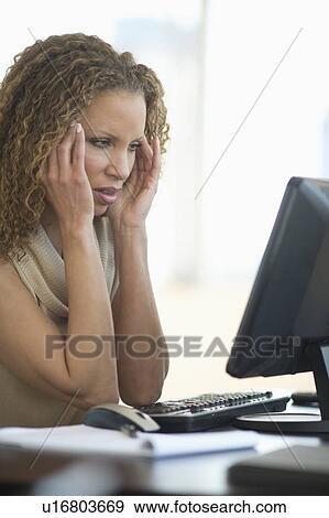 Stock Photo - Business woman having headache in office. Fotosearch