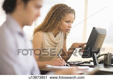 Stock Image - Business woman working in office. Fotosearch