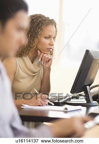 Stock Photo - Business woman working in office. Fotosearch