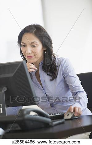 Stock Photograph - Business woman working on computer. Fotosearch