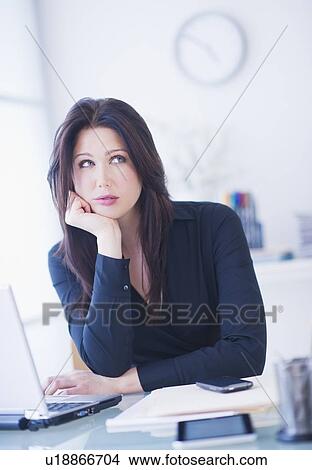 Businesswoman sitting at desk View Large Photo Image Picture - Businesswoman sitting at desk. Fotosearch