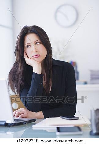 Businesswoman sitting at desk View Large Photo Image Stock Photo - Businesswoman sitting at desk. Fotosearch