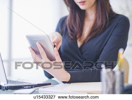 Stock Photo - Businesswoman using digital tablet. Fotosearch
