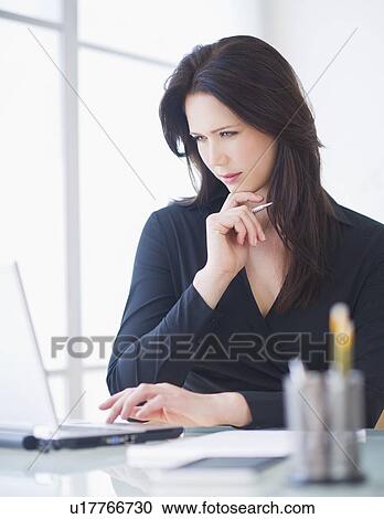 Businesswoman working at desk View Large Photo Image Stock Image - Businesswoman working at desk. Fotosearch