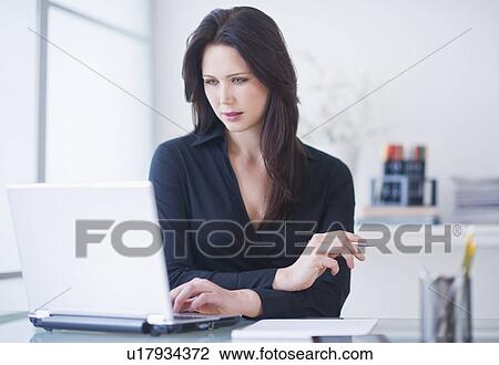 Businesswoman working at desk View Large Photo Image Stock Image - Businesswoman working at desk. Fotosearch